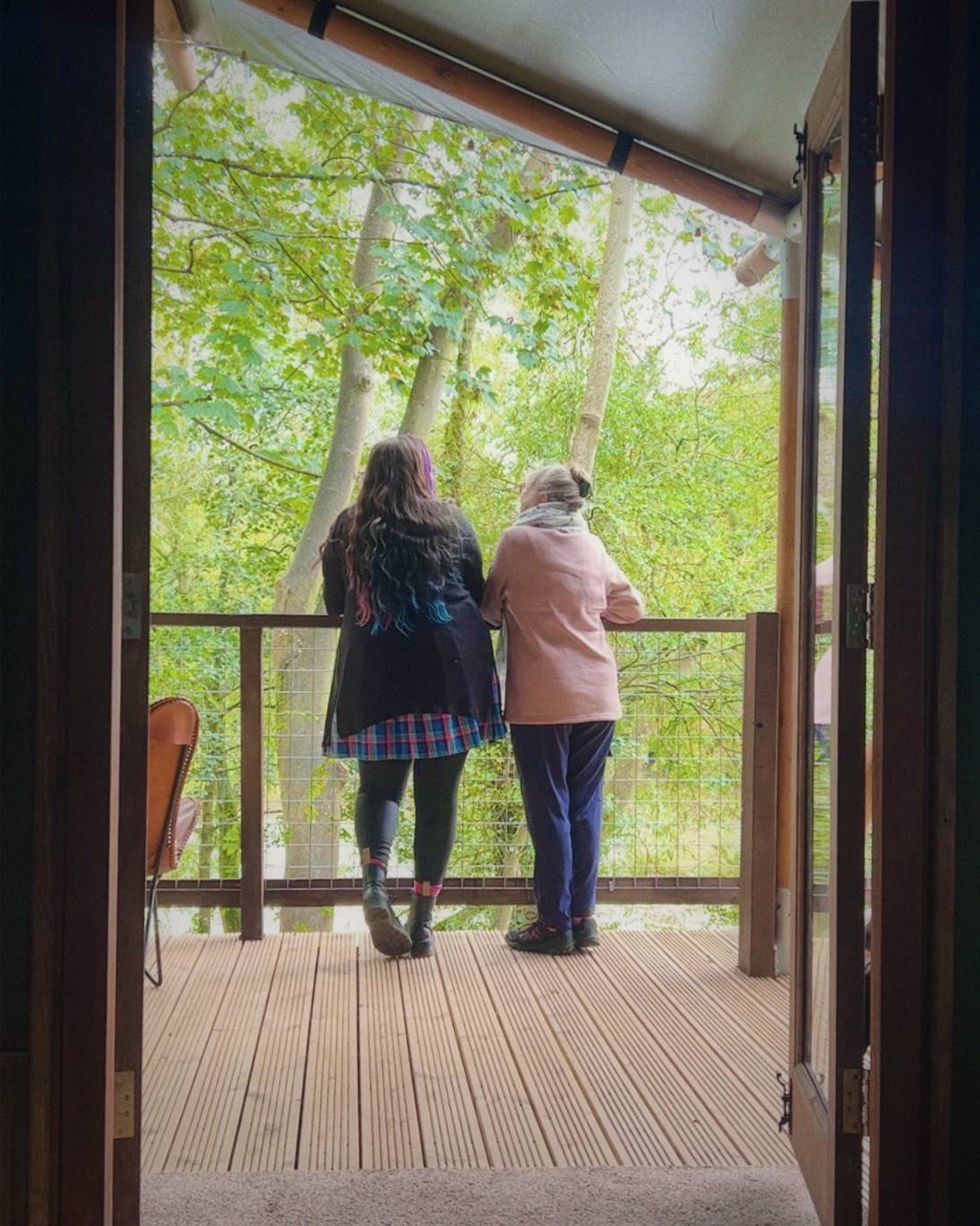 Luisa and her mum stand ont he balcony 
