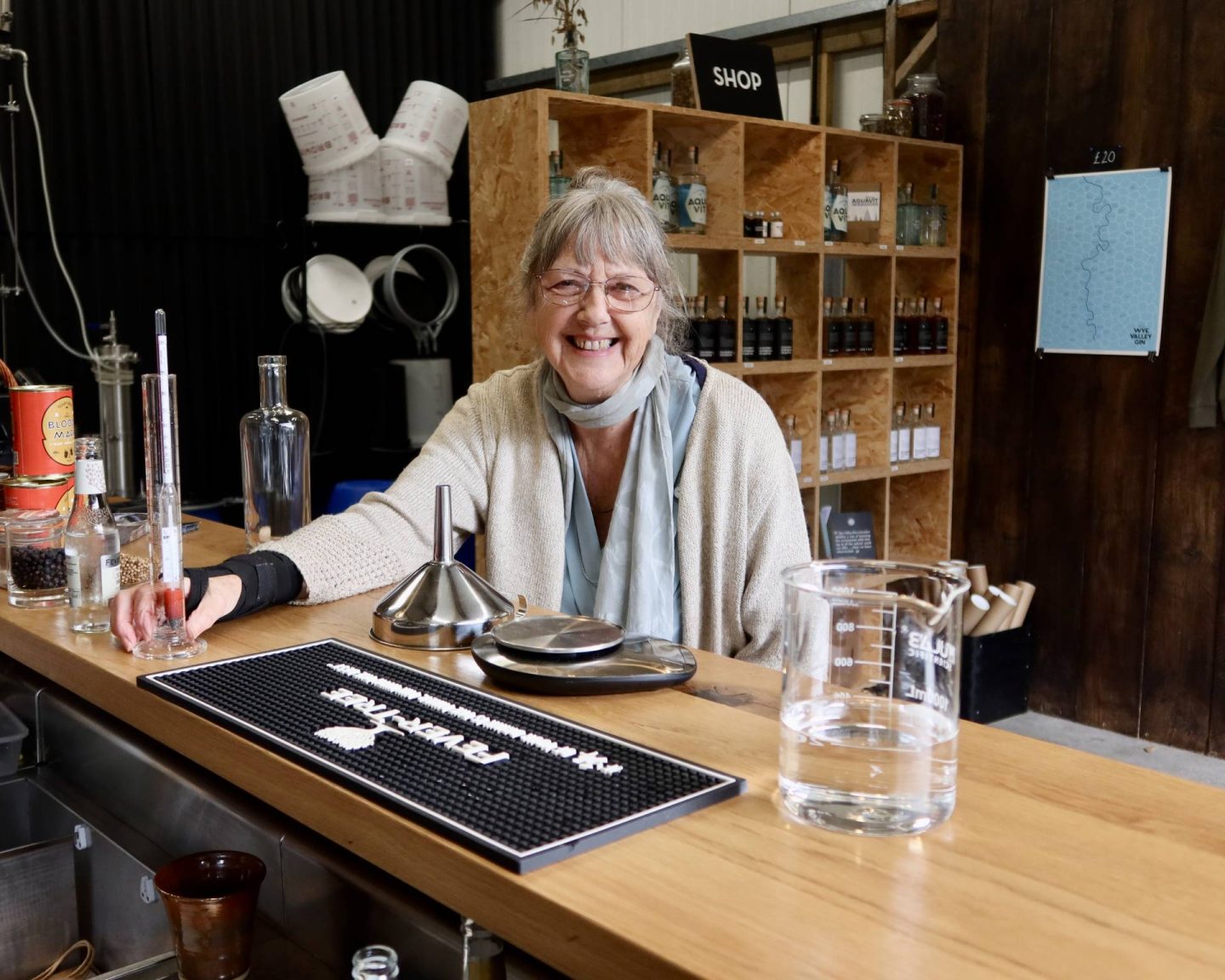 Luisa's mum grinning in Silver Circle Distillery after measuring out the gin she made at Silver Circle Distillery.