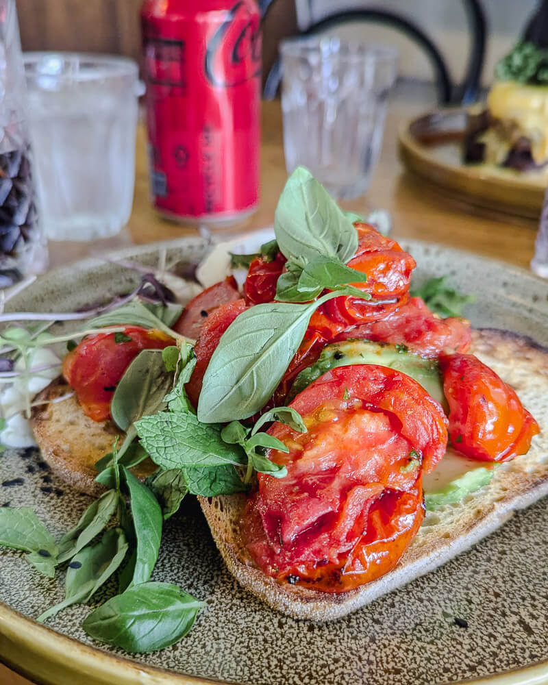 Heirloom tomatoes with basil garnish on two slices of sourdough at Hot Poppy, Melbourne