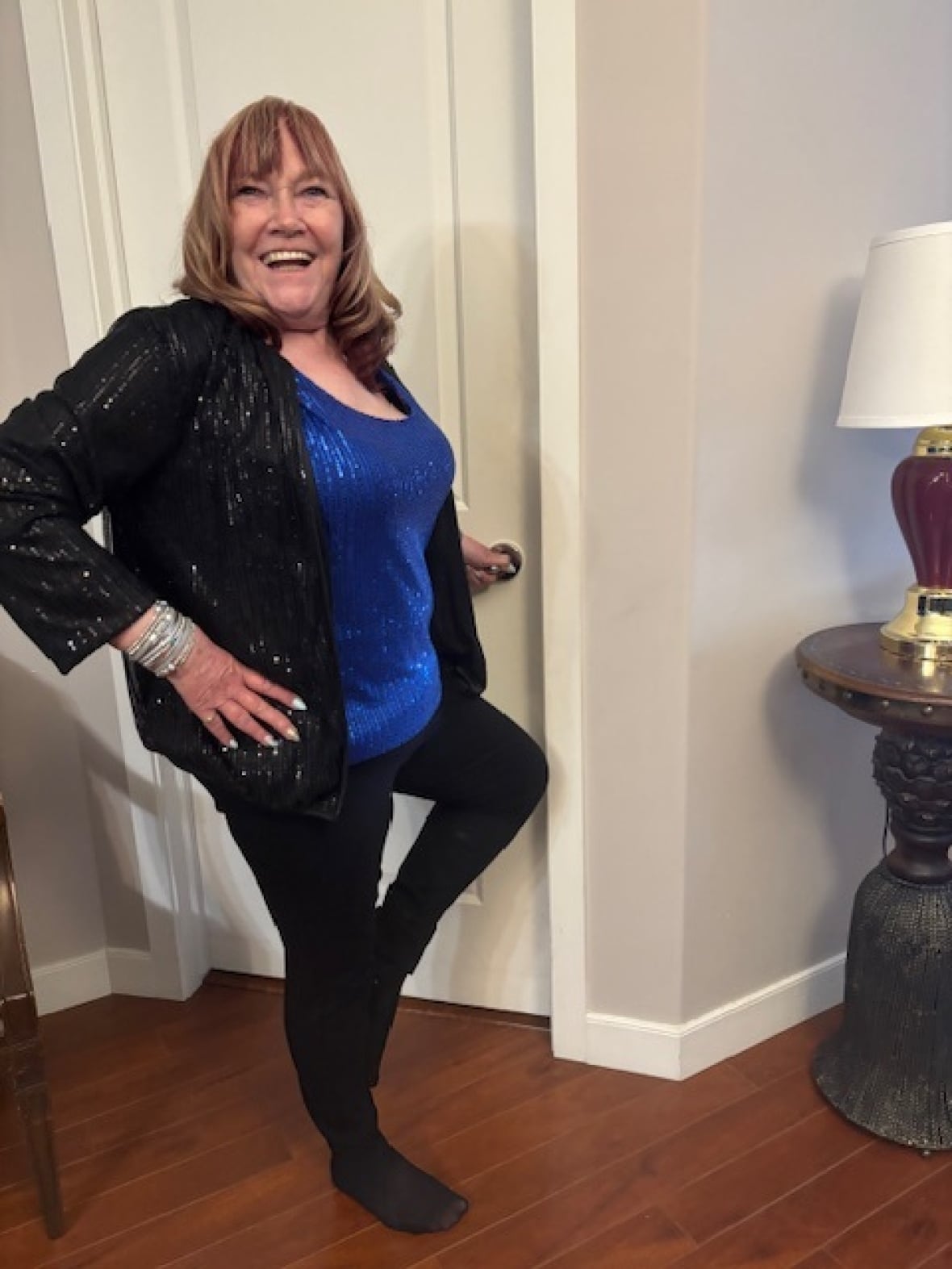 Woman poses in sparkly black and blue outfit.
