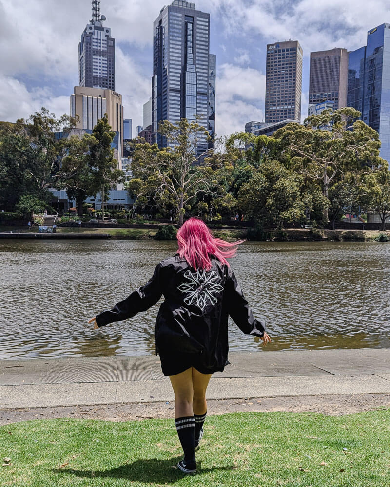 Pink haired girl walking in front of a river in Melbourne