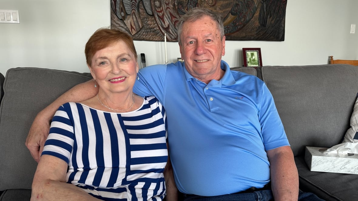A man and a woman sit on a couch. 
