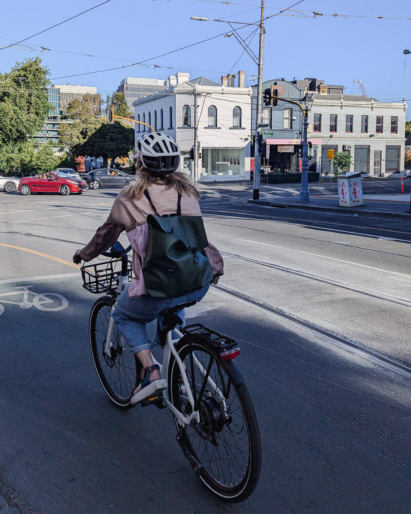 Woman riding bike along the road in Melbourne
